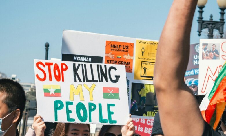man in black polo shirt holding white and yellow signage during daytime